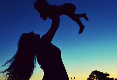 Woman lifting baby in the air